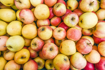 Lots of colorful apples on the market, texture of apples.