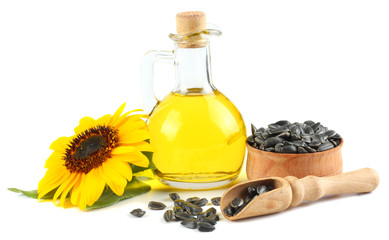 Sunflower oil in glass jug, seeds and flower isolated on white background