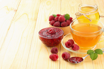 healthy background. raspberry with raspberry jam, honey and tea on light wooden background. top view with copy space