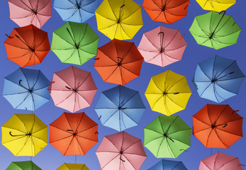 Fototapeta na wymiar Bright colorful umbrellas hanging high above the street