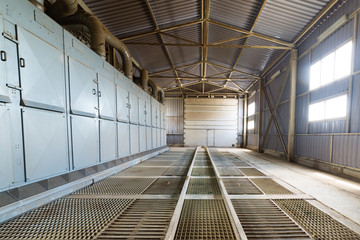 A large hangar with a floor made of steel gratings.