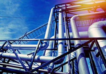 Industrial zone, Steel pipelines and valves against blue sky