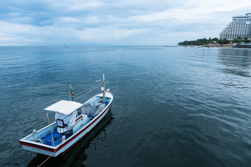 Fototapeta premium Fishing boats floating in the sea over cloudy sky at Prachuap Khiri Khan, Thailand.