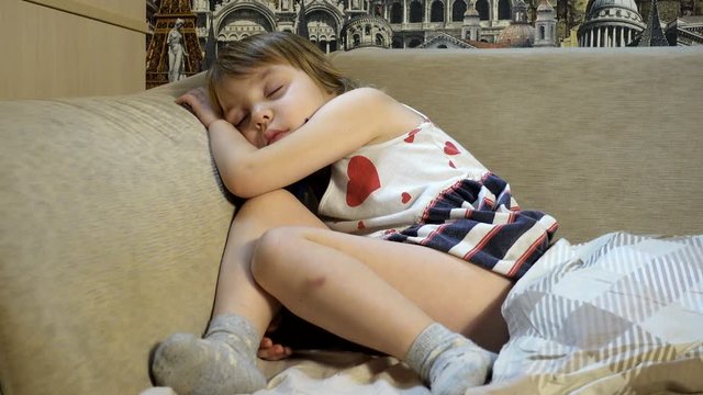 4K footage. Sleeping baby. A European-looking girl with blond hair, 4-5 years old in a dress, fell asleep without undressing.
