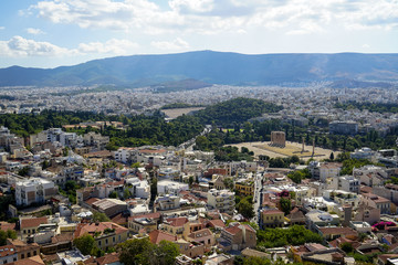 Panoramic view of Athens city from Acropolis seeing ancient ruin, building architecture, urban street, trees, mountain and bright sky background