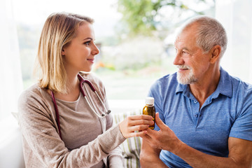 Health visitor and a senior man during home visit.
