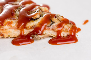 Closeup macro of pizza slice with ham mushrooms and ketchup on t