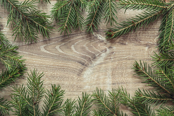Christmas fir tree branches on wooden background. Space for text. Top view.