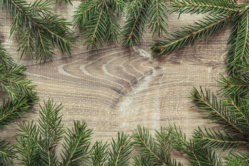 Obraz premium Christmas fir tree branches on wooden background. Space for text. Top view.