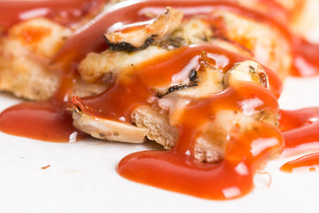 Closeup macro of pizza slice with ham mushrooms and ketchup on the white marble