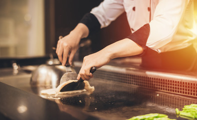 Hand of man take cooking of meat with vegetable grill, Chef cooking wagyu beef in Japanese teppanyaki restaurant