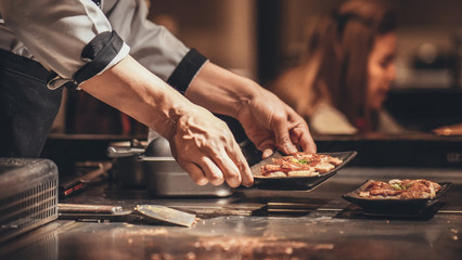 Hand of man take cooking of meat with vegetable grill, Chef cooking wagyu beef in Japanese teppanyaki restaurant - obrazy, fototapety, plakaty