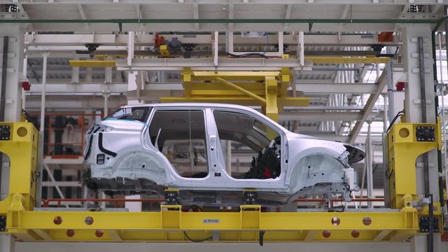 Automobile plant, new car body moves along the conveyor, modern production of cars, automated production line.
