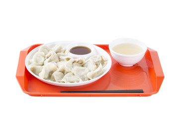 Chinese food JIAOZI, soup and chopsticks on a tray.