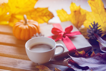 Gift box and maple leaves wih cup of coffee