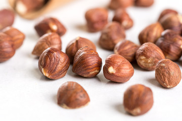 Closeup macro of raw hazelnuts on the white marble background