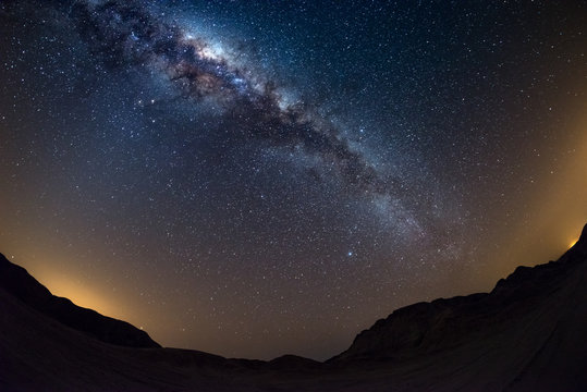 Starry sky and Milky Way arch, with details of its colorful core, outstandingly bright, captured from the Namib desert in Namibia, Africa. The Small Magellanic Cloud on the left hand side.