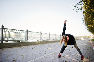 Young girl has the training and doing exercise outdoors. Sport, fitness, street workout concept.