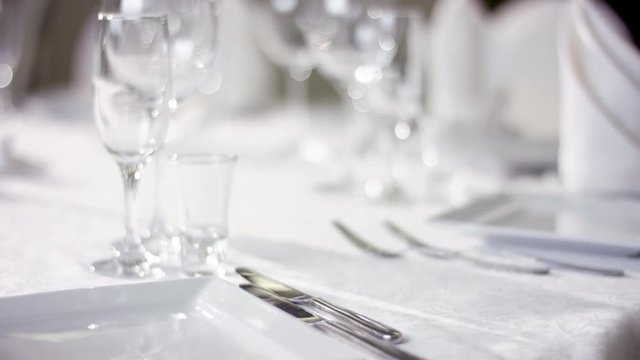 View of waiter hand preparing the dinner table for the wedding at banquette hall at restaurant