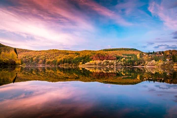 Fotobehang Blauwe hemel Stunning beautiful landscape of a lake Pasarel in Bulgaria, near Sofia city on a sunset with yellow and orange trees on a background and reflection in the water.  © Evgeni