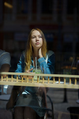 Nice girl behind glass of cafe.