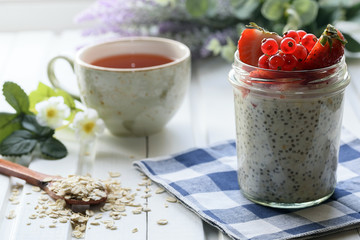 Healthy Homemade Breakfast concept: Oatmeal with seeds in a glass jar. With fresh berries.