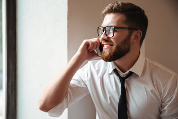 Portrait of a young happy businessman in eyeglasses