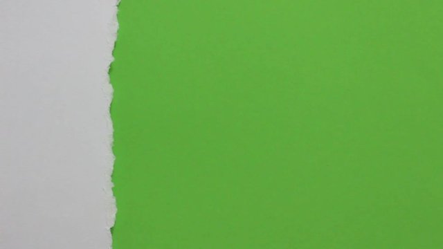 Close up of paper tearing into green screen background