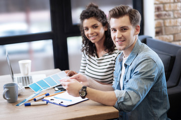 Inspired girl and boy sitting at the table and working