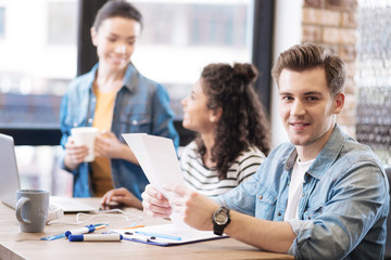 Smiling man holding a sheet of paper