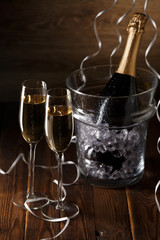 Picture of two glasses, bucket of ice and bottle of wine
