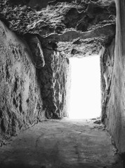 White window out of the cave. The light at the end of the tunnel. Black-and-white photo.