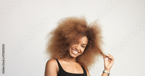 Mixed Race Black Woman With Blonde Curly Hair In Studio Happy