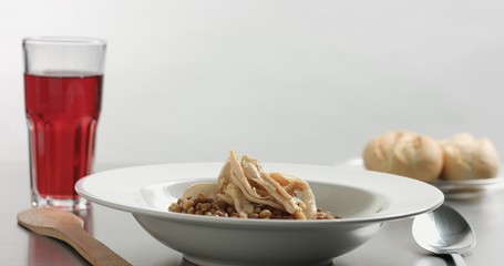 Delicious freshly made hot steaming chicken and lentil soup in a white wide-rimmed plate