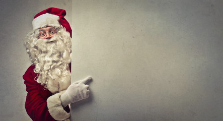 Santa Claus pointing at a blank space - obrazy, fototapety, plakaty