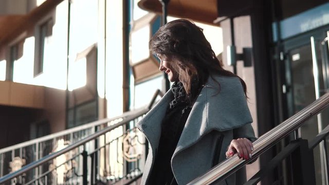 portrait of a business woman in a coat against a modern architecture background