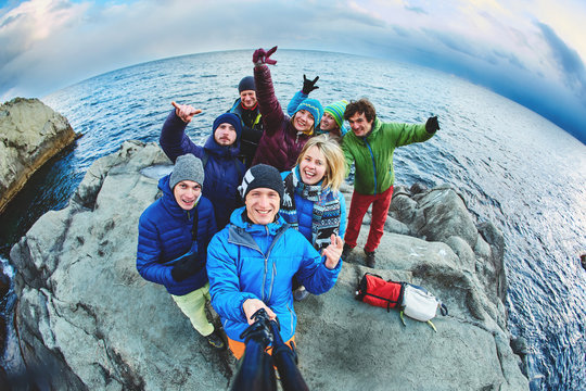 funny laughing friends near the sea in winter taking selfie together