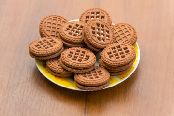 Chocolate cookies with cream filling on wooden table