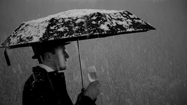 gentleman with umbrella in the cold, the snow,drinking champagne,