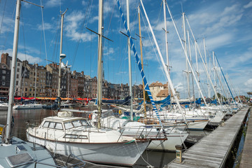 Yachts moored at quay port of Honfleur, France. Concepts of success, leisure, holiday, rich, tourism, luxury, lifestyle. Sunny Summer, blue sky