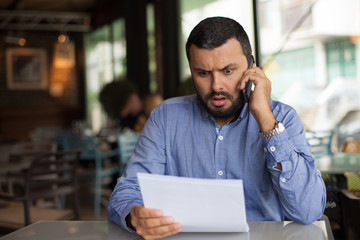 Worried man reading a letter