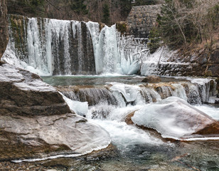 Ice cascades on the mountain river. Mountain stream runs over cascades and waterfalls and partially freezes. Dovzan Gorge in Karavanke mountain range. Slovenia.
