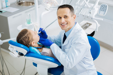 Delighted smart dentist looking at you