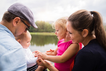 Happy family in nature by the lake in summer.
