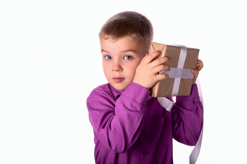 Smiling funny child holds a gift in his hands.