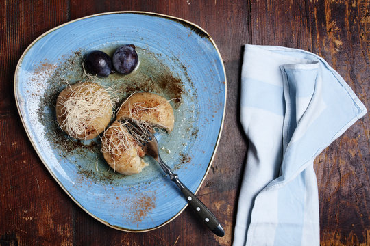 Plum gnocchi with cheese on the azure dish.