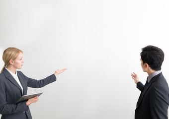 Two business persons in front of white blank space.