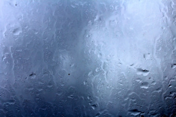 Drops on the glass. Background image in blue.