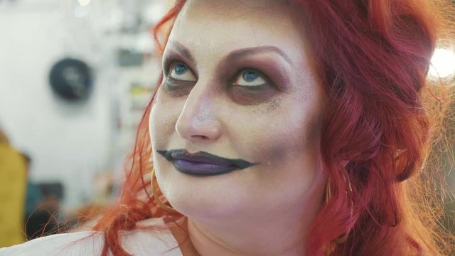 Close-up portrait of redhead woman with halloween makeup at beauty salon