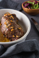 Delicious spicy meat. Spicy meat baked with chili pepper. Piece of baked meat with spices and vegetables on the table. Spicy baked meat prepared for eat.